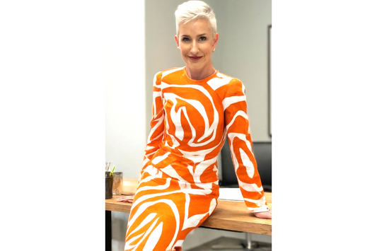 chic mature fashionable woman with short grey hair cut and orange and white dress